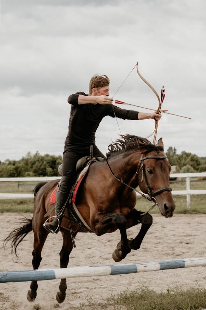 A skilled horse archer shooting an arrow while galloping outdoors.