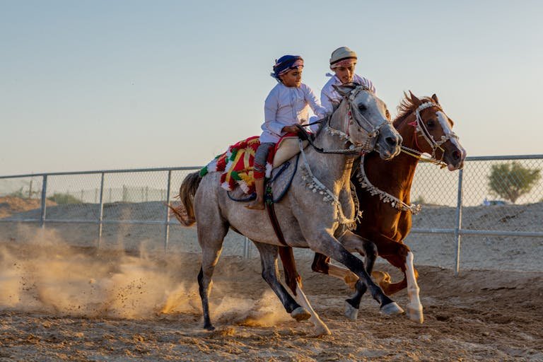 A young boy and father enjoy traditional horseback riding in a vibrant outdoor setting.